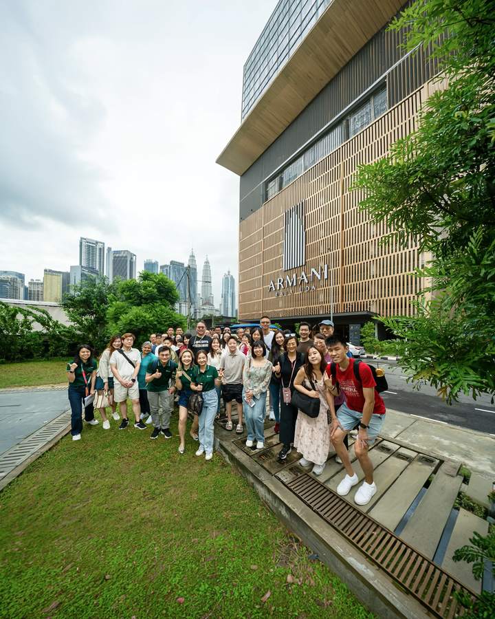 Crestbrick clients outside a Kuala Lumpur development with the city skyline behind them